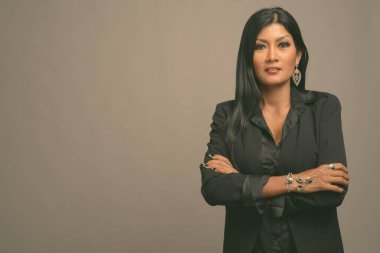 Asyalı güzel bir iş kadınının gri arka planda çekilmiş bir stüdyo fotoğrafı.