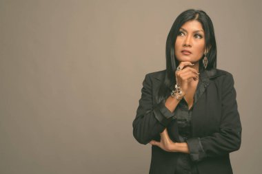 Asyalı güzel bir iş kadınının gri arka planda çekilmiş bir stüdyo fotoğrafı.