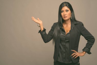 Asyalı güzel bir iş kadınının gri arka planda çekilmiş bir stüdyo fotoğrafı.