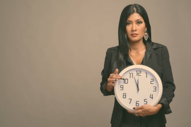 Asyalı güzel bir iş kadınının gri arka planda çekilmiş bir stüdyo fotoğrafı.