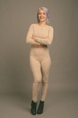 Stüdyo çekimlerinde, gri arka planda renkli saçlı güzel asi kadın görülüyor.