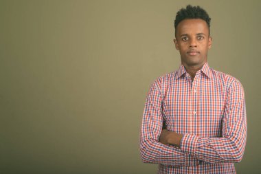Renkli arka planda mor kareli gömlek giyen yakışıklı Afrikalı iş adamının stüdyo fotoğrafı.