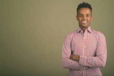 Renkli arka planda mor kareli gömlek giyen yakışıklı Afrikalı iş adamının stüdyo fotoğrafı.