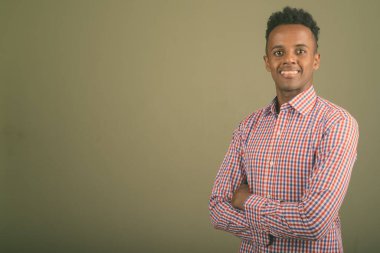 Renkli arka planda mor kareli gömlek giyen yakışıklı Afrikalı iş adamının stüdyo fotoğrafı.