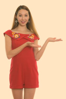 Beyaz arka planda izole edilmiş genç ve güzel Asyalı bir kadının stüdyo çekimi.