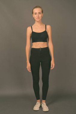 Gri arka planda jimnastiğe hazır güzel bir kadının stüdyo çekimi.