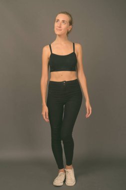 Gri arka planda jimnastiğe hazır güzel bir kadının stüdyo çekimi.