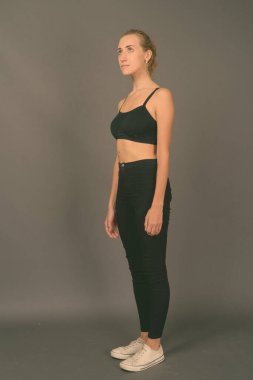 Gri arka planda jimnastiğe hazır güzel bir kadının stüdyo çekimi.