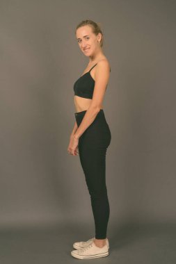 Gri arka planda jimnastiğe hazır güzel bir kadının stüdyo çekimi.