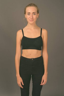 Gri arka planda jimnastiğe hazır güzel bir kadının stüdyo çekimi.