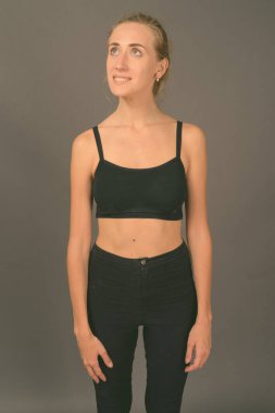 Gri arka planda jimnastiğe hazır güzel bir kadının stüdyo çekimi.