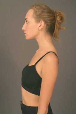 Gri arka planda jimnastiğe hazır güzel bir kadının stüdyo çekimi.