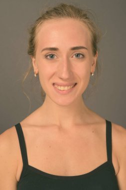 Gri arka planda jimnastiğe hazır güzel bir kadının stüdyo çekimi.