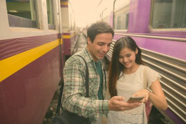 Yakışıklı İranlı turist ve güzel Asyalı turist kadının portresi. Bangkok, Tayland 'daki tren istasyonunda birlikte.