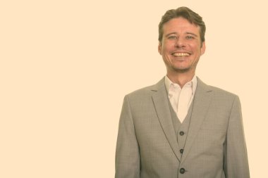 Kısa saçlı, beyaz bir adamın portresi stüdyo arka planında.