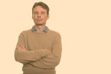 Kısa saçlı, beyaz bir adamın portresi stüdyo arka planında.