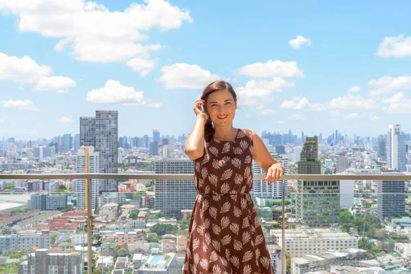 Portrét krásné ženy usmívající se venku na střeše s výhledem na město — Stock fotografie