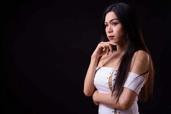 Junge schöne asiatische Transgender-Frau vor schwarzem Hintergrund — Stockfoto