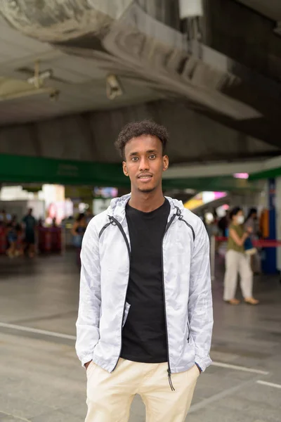 Πορτρέτο του όμορφος μαύρος Αφρικανός με δροσερό στάση στο σιδηροδρομικό σταθμό στην Μπανγκόκ — Φωτογραφία Αρχείου