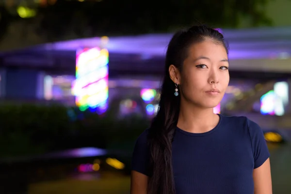 Portrait of beautiful Korean woman outdoors at night