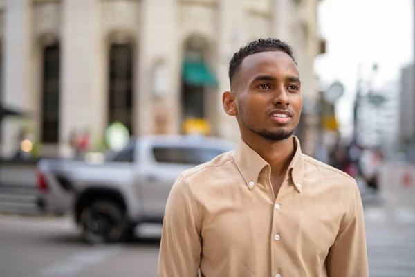 都市の屋外でカジュアルな服を着てハンサムな黒の若いアフリカのビジネスマンの肖像画 — ストック写真