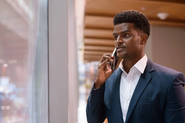 Porträtt Afrikansk Affärsman Står Bredvid Fönstret Och Talar Mobiltelefon Inomhus — Stockfoto