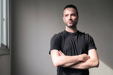 Siyah tişörtlü, sakallı yakışıklı bir adamın portresi.