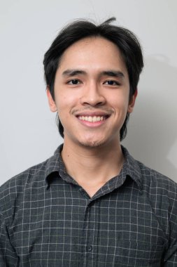 Beyaz arka planda 20 'li yaşlarda yakışıklı Asyalı genç Taylandlı bir adamın portresi