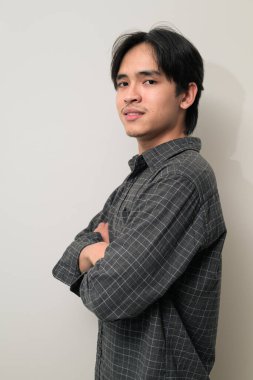 Beyaz arka planda 20 'li yaşlarda yakışıklı Asyalı genç Taylandlı bir adamın portresi