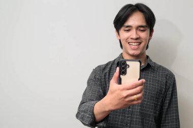 Beyaz arka planda 20 'li yaşlarda yakışıklı Asyalı genç Taylandlı bir adamın portresi