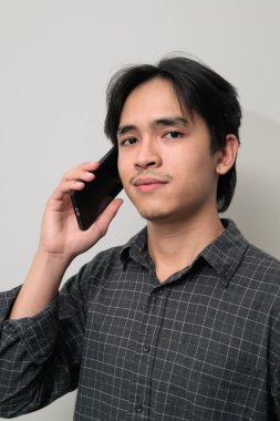 Beyaz arka planda 20 'li yaşlarda yakışıklı Asyalı genç Taylandlı bir adamın portresi