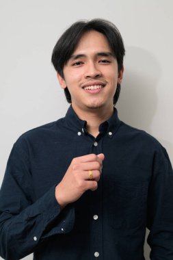 Beyaz arka planda 20 'li yaşlarda yakışıklı Asyalı genç Taylandlı bir adamın portresi