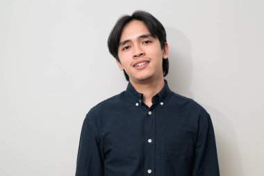 Beyaz arka planda 20 'li yaşlarda yakışıklı Asyalı genç Taylandlı bir adamın portresi