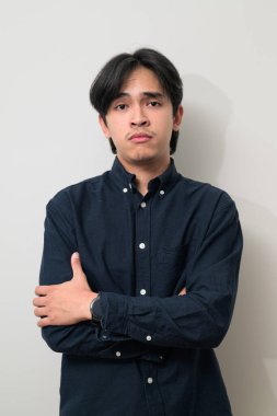 Beyaz arka planda 20 'li yaşlarda yakışıklı Asyalı genç Taylandlı bir adamın portresi