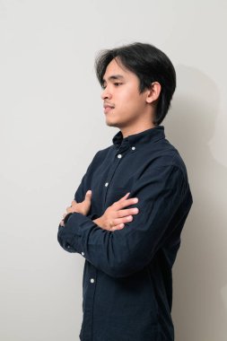 Beyaz arka planda 20 'li yaşlarda yakışıklı Asyalı genç Taylandlı bir adamın portresi