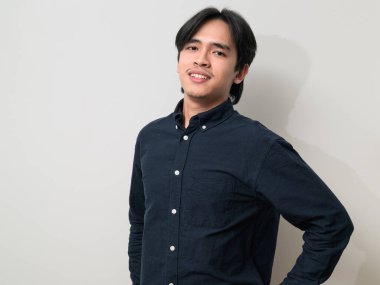 Beyaz arka planda 20 'li yaşlarda yakışıklı Asyalı genç Taylandlı bir adamın portresi