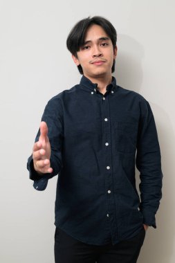 Beyaz arka planda 20 'li yaşlarda yakışıklı Asyalı genç Taylandlı bir adamın portresi