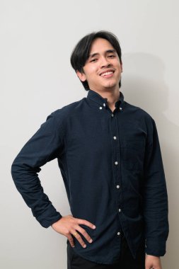 Beyaz arka planda 20 'li yaşlarda yakışıklı Asyalı genç Taylandlı bir adamın portresi