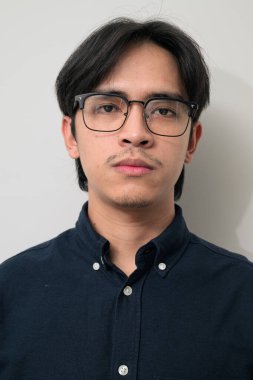 Beyaz arka planda 20 'li yaşlarda yakışıklı Asyalı genç Taylandlı bir adamın portresi