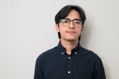 Beyaz arka planda 20 'li yaşlarda yakışıklı Asyalı genç Taylandlı bir adamın portresi