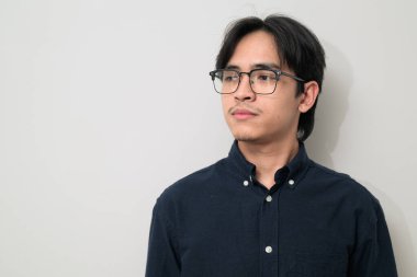 Beyaz arka planda 20 'li yaşlarda yakışıklı Asyalı genç Taylandlı bir adamın portresi