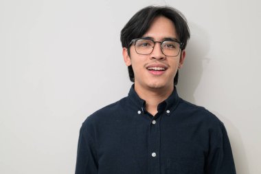 Beyaz arka planda 20 'li yaşlarda yakışıklı Asyalı genç Taylandlı bir adamın portresi