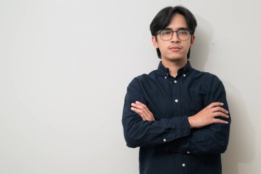 Beyaz arka planda 20 'li yaşlarda yakışıklı Asyalı genç Taylandlı bir adamın portresi