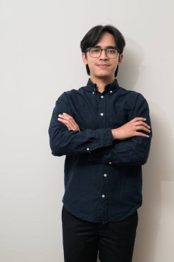 Beyaz arka planda 20 'li yaşlarda yakışıklı Asyalı genç Taylandlı bir adamın portresi