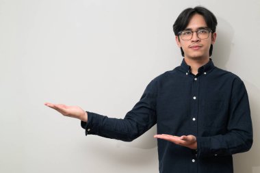 Beyaz arka planda 20 'li yaşlarda yakışıklı Asyalı genç Taylandlı bir adamın portresi