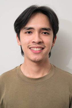 Beyaz arka planda 20 'li yaşlarda yakışıklı Asyalı genç Taylandlı bir adamın portresi