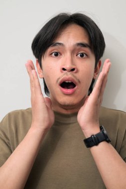 Beyaz arka planda 20 'li yaşlarda yakışıklı Asyalı genç Taylandlı bir adamın portresi