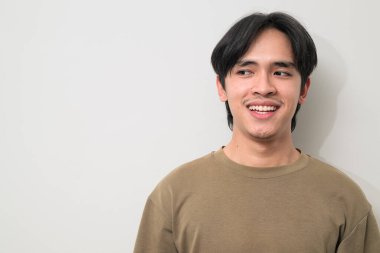 20 'li yaşların başında beyaz arka planda yaşayan yakışıklı Asyalı genç bir adamın portresi.