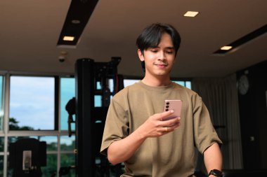 20 'li yaşların başındaki yakışıklı Asyalı Taylandlı adamın gece boyunca spor salonunda portresi.