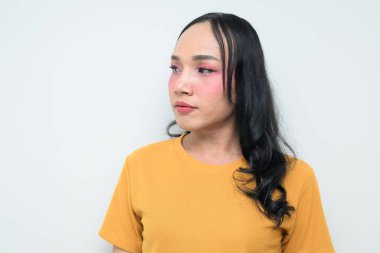 Makyajlı ve uzun saçlı Taylandlı genç bir transseksüelin stüdyo portresi. Cinsiyet ifadesi kavramı, LGBTQ gururu ve özgün güzellik ve çeşitliliği gösteren kapsayıcılık.